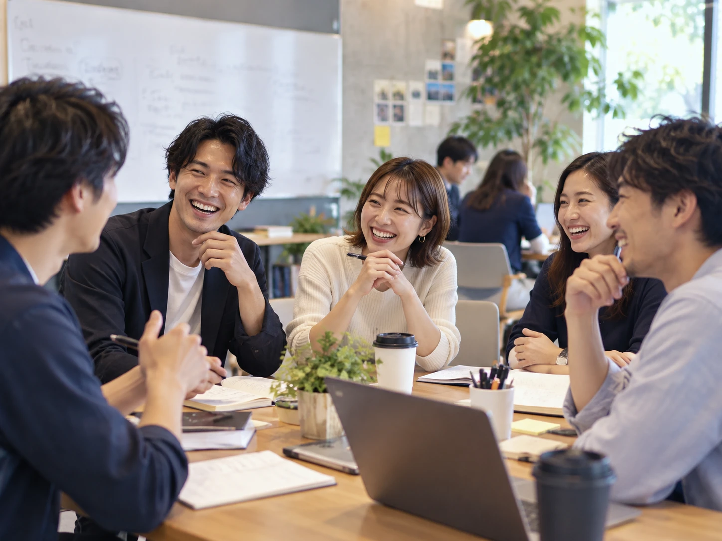 テーブルを囲んで笑い合う若手の営業パーソンたち